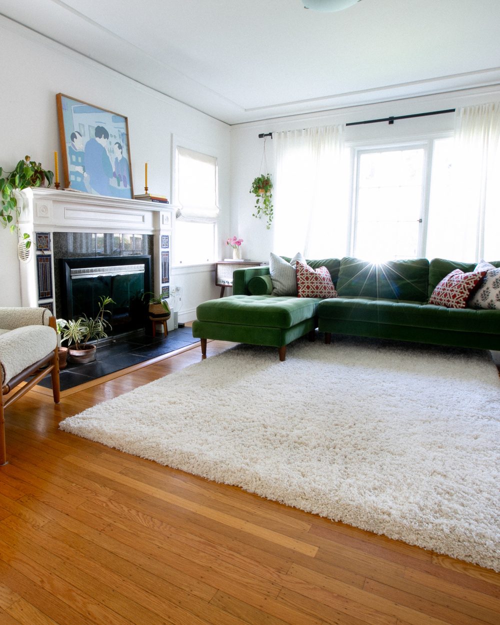 Living room with a green velvet sectional and white shag rug