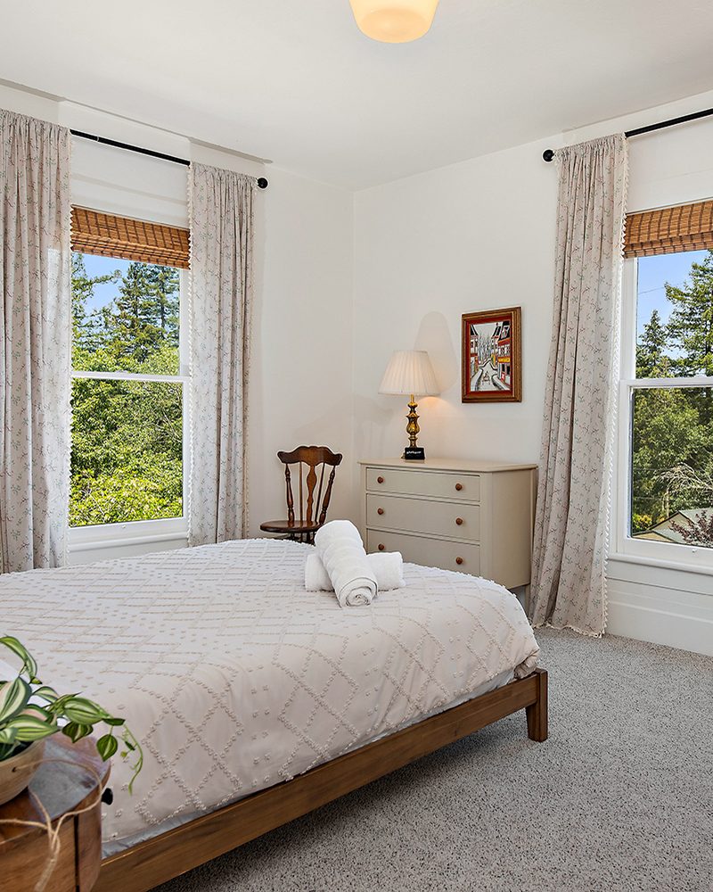 Bedroom with treetop views and floral curtains